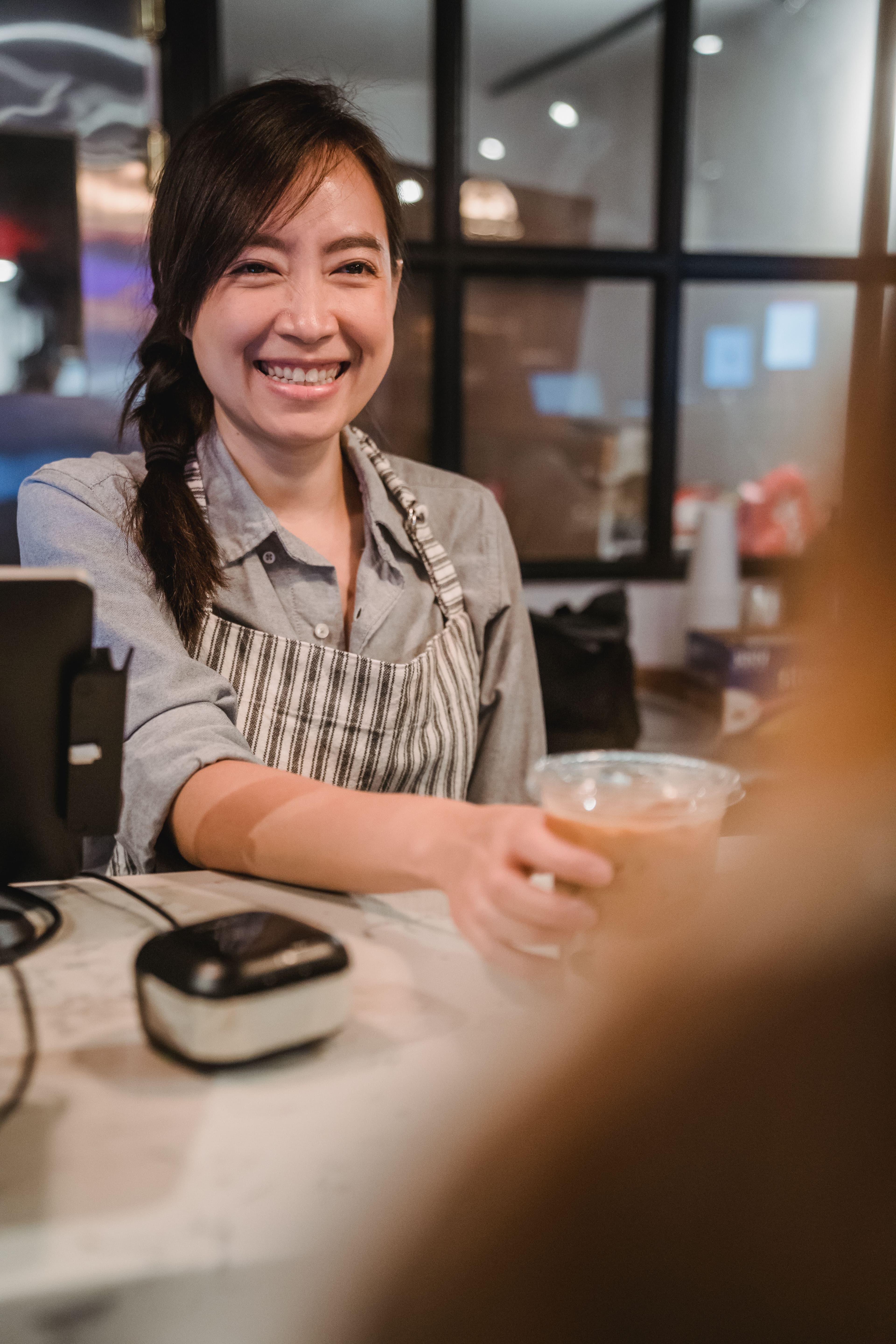 Barista handing a coffee to a guest